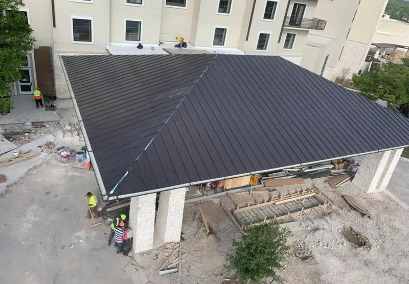 Metal roofing installation team working on a commercial building in Brunswick